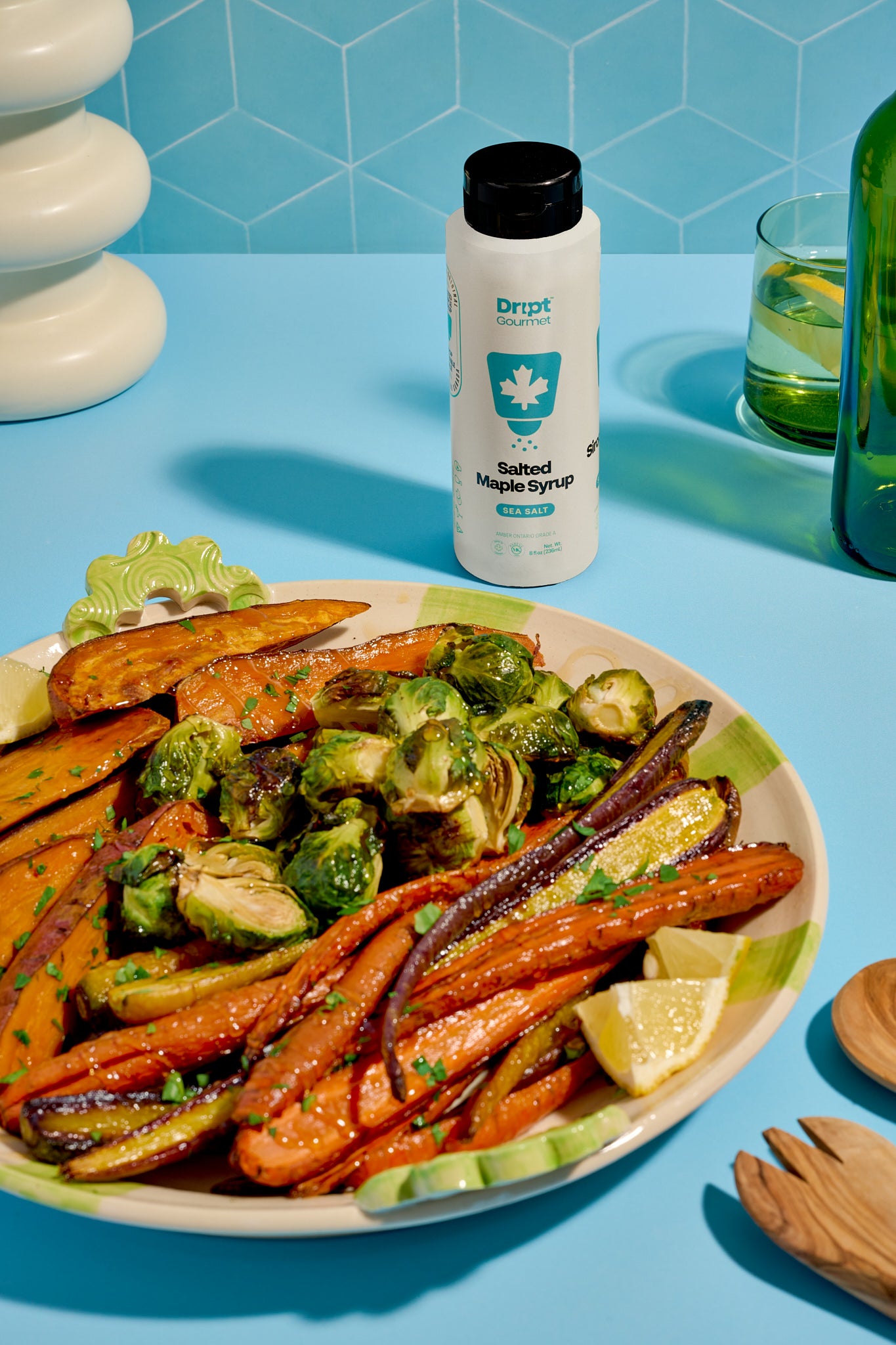 Dript Gourmet Salted Maple Syrup bottle with roasted veggies on a light blue table. Artisanal Canadian maple syrup infused with sea salt.